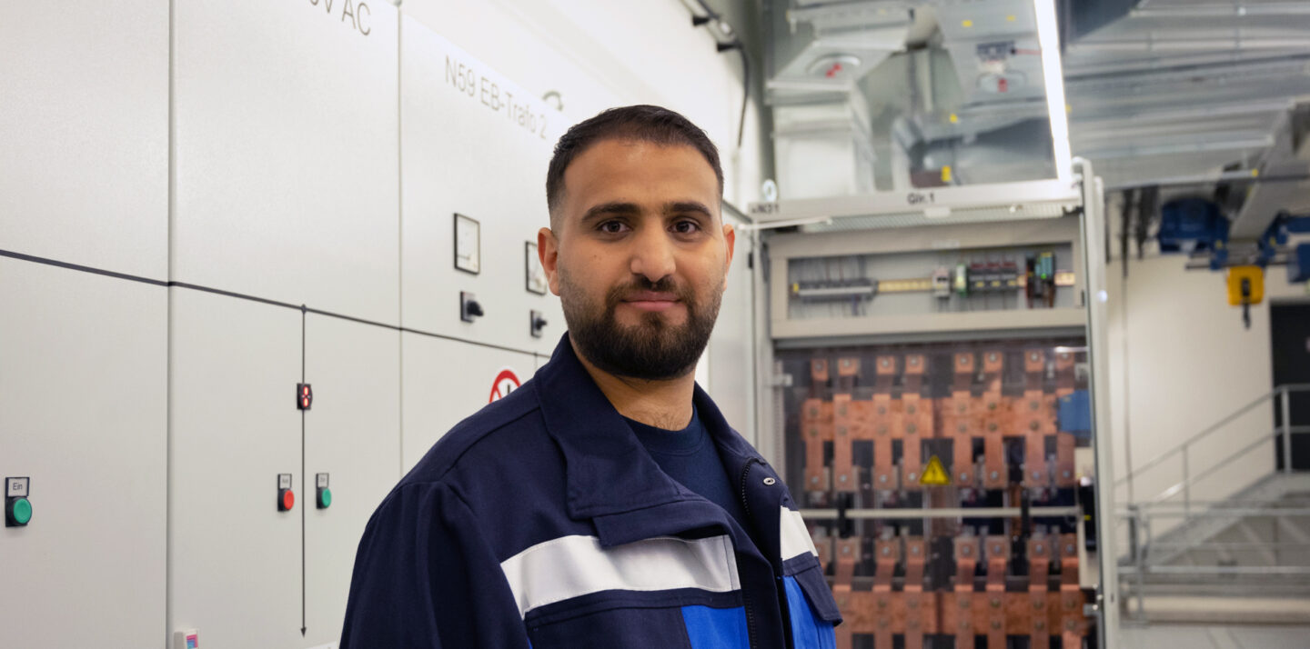 Elektroniker Bassel steht vor den Anlagen in einem Gleichrichterwerk